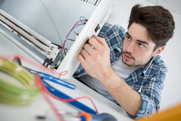 young repairer working with screwdriver in service center