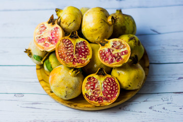 Pomegranate fruit on a wooden plate