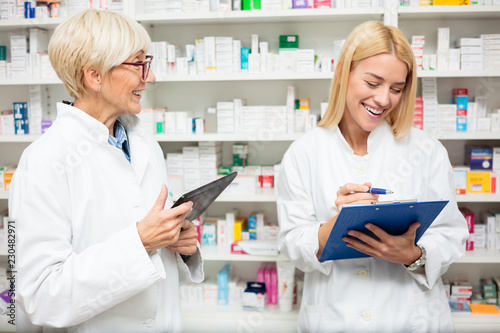 Pharmacists Working By Shelves In Pharmacy
