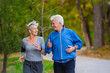 © lordn - Smiling senior couple jogging in the park