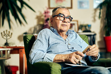 Jewish Senior With Glasses Sitting In The Armchair Reading A Torah Book