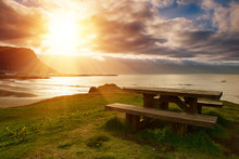 A Picnic Wooden Table With Gorgeous View At Ocean With Sun Shining Through The Clouds In Iceland. Place For Rest Travel Concept.