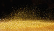 Golden powder scattered over the dark background