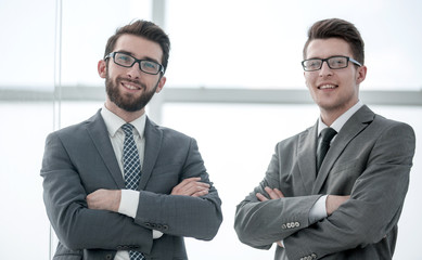 Wall Mural - two confident businessman standing near the office window