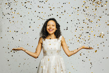 Celebrate Life, Portrait Of A Smiling Woman With Arms Out And Golden Confetti Falling