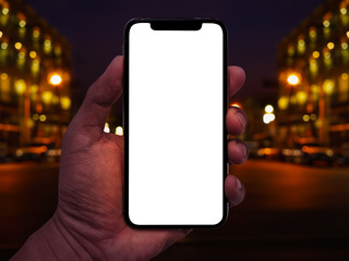 Aufkleber - Hand holding smartphone with abstract bokeh of city night light background.