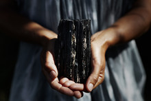 Woman's Hands Holding Dark, Powerful Black Tourmaline Crystal In Healing Concept