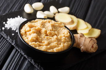 Sticker - Asian ginger garlic paste with fresh ingredients close-up in a bowl on a black table. horizontal