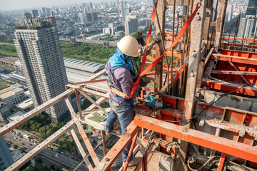 Construction worker wear standard personal protective equipment dismantle steel structure at height rise building project