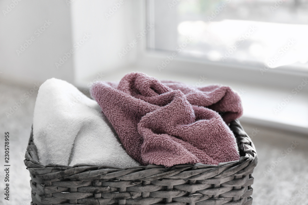 Laundry basket with dirty towels near window