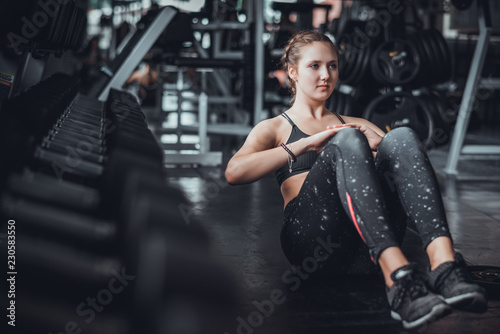 Fotografie, Obraz Cinematic tone of young attractive fitness woman exercise with machine in gym