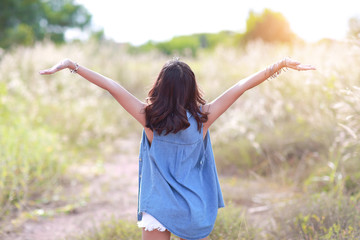 young and cute girl having a happy time and enoying amoung grass field in nature