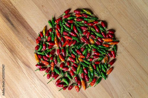 Fotografia Colorful Chilli Peppers On Wooden Table. High Angle View