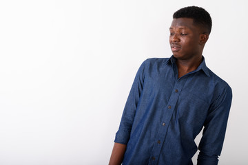 Wall Mural - Studio shot of young black African man thinking while looking di