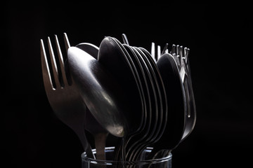 Lot of metal cutlery on a black background. Selective focus. Shallow depth of field