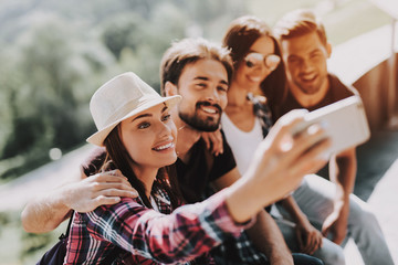 Wall Mural - Young Smiling People Sitting in Park taking Selfie