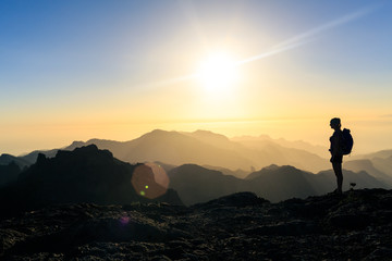 Wall Mural - woman hiking success silhouette in mountains sunset