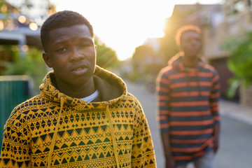 Wall Mural - Young black African man with young slim black African man thinki