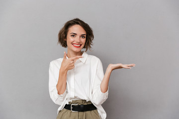 Wall Mural - Portrait of a cheerful young woman presenting copy space