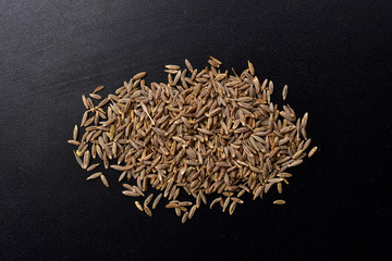 Wall Mural - cumin seeds on black textured background , jeera spice