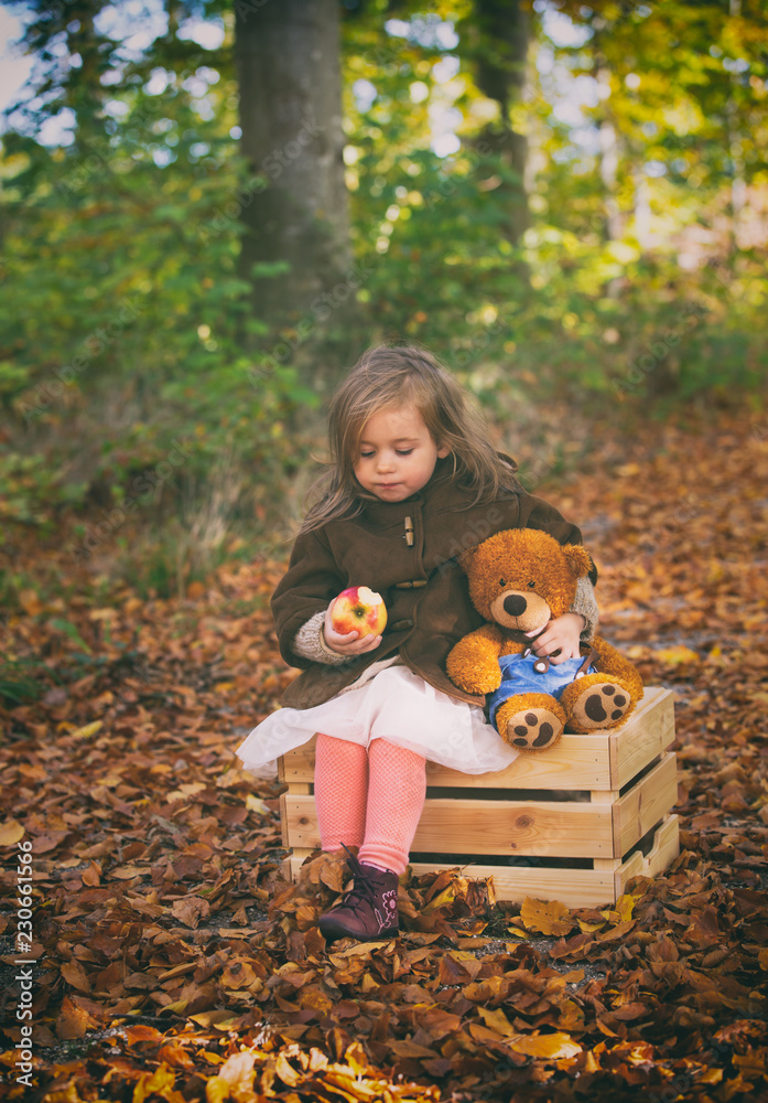 Fairy little girl sitting on a wooden chest in the forest with her ...