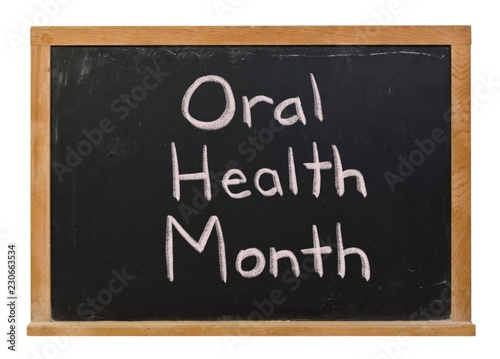 Fotografie, Obraz Oral Health Month written in white chalk on a black chalkboard isolated on white