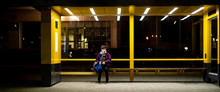 Young Man Sit On The Bus Stop Bench Waiting In The Night F