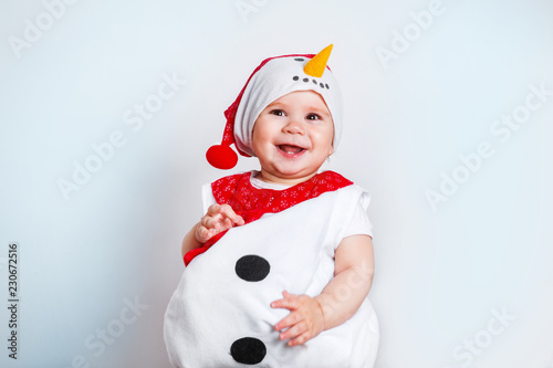Fototapeta Merry Christmas and Happy New Year. Happy baby girl in snowman costume on white background