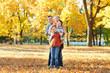 © soleg - Happy family walks in autumn city park. Children and parents posing, smiling, playing and having fun. Bright yellow trees.