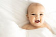 A Cute baby girl on a white bed at home