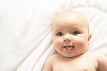 Wall Mural - A Cute baby girl on a white bed at home