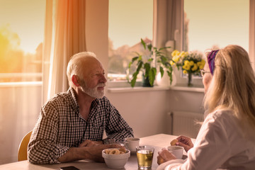 Old couple drinking coffee at table