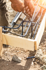 Wall Mural - Worker Securing Steel Rebar Framing With Wire Plier Cutter Tool At Construction Site