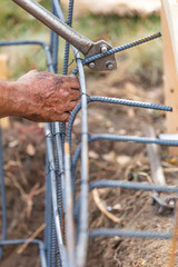 Wall Mural - Worker Using Tools To Bend Steel Rebar At Construction Site