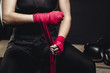 Woman wraps her fists in pink bandages for boxing gloves