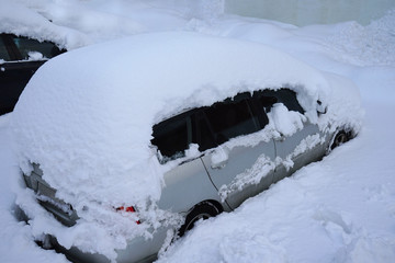 Wall Mural - Car covered with much snow.