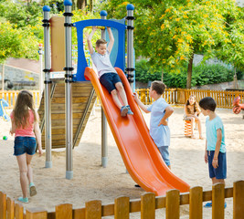 Wall Mural - Kids playing on the slide at playground