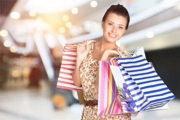 Wall Mural - Young woman with shopping bags on  background