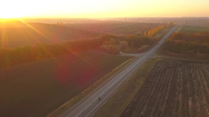 Wall Mural - Aerial: fly cam follow motorbike on the road at sunset time