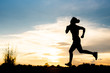 © stcom - silhouette woman running alone at beautiful sunset in the park.