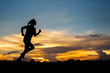 © stcom - silhouette woman running alone at beautiful sunset in the park.