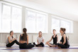 © fizkes - Group at yoga sport seminar in professional training studio. Girls and guys sitting together listen teacher coach ask questions communicating learn more about spiritual mental physical yoga practices