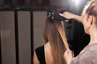 © luckyphoto - professional hairdresser making a gauffer hairdo of a model with long hair in a beauty salon. concept of stylist training