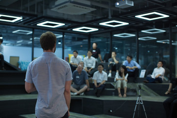 Fototapete - Speaker Giving Lecture at Tech Business Seminar. Audience at Conference Hall. Business Entrepreneurship Education Event. Young Presenter Gives Presentation Talk During Conference. Technology Workshop.