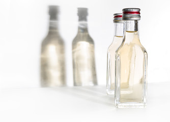 Two bottles of vintage alcohol with shadows on the wall.