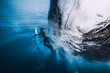 Professional surfer with surfboard dive underwater. Alone surfer under big ocean wave.