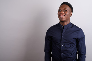 Portrait of young African businessman against white background