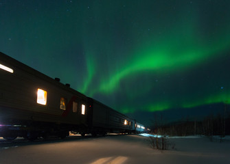 train and aurora borealis over the tundra, russia