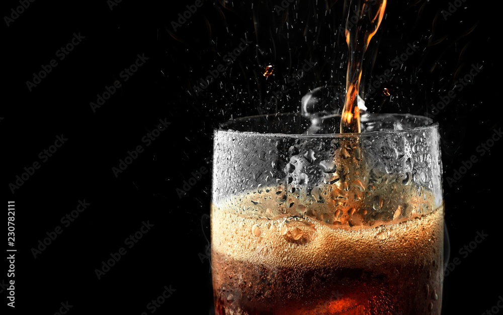 Soft drink glass with ice splash on dark background. Cola glass in celebration party concept. - obrazy, fototapety, plakaty 