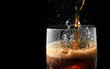 Soft drink glass with ice splash on dark background. Cola glass in celebration party concept.